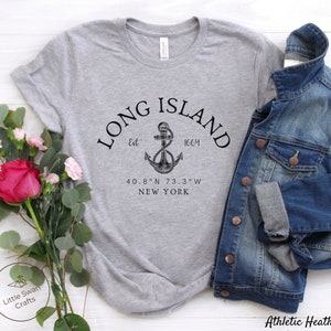 Op de afbeelding: Grijs T-shirt met een zwarte afbeelding van een anker en de tekst "LONG ISLAND Est 1664 40.8&deg;N 73.3&deg;W NEW YORK".