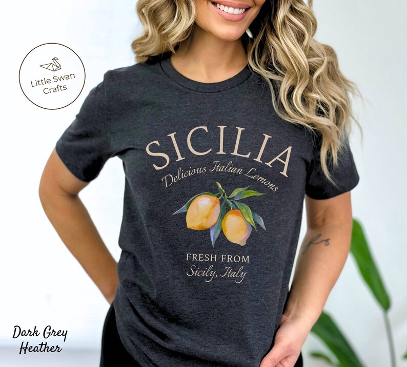 Peut inclure: T-shirt en jersey gris fonc&eacute; chin&eacute; avec un motif graphique repr&eacute;sentant des citrons et le texte "SICILIA Delicious Italian Lemons FRESH FROM Sicily, Italy".