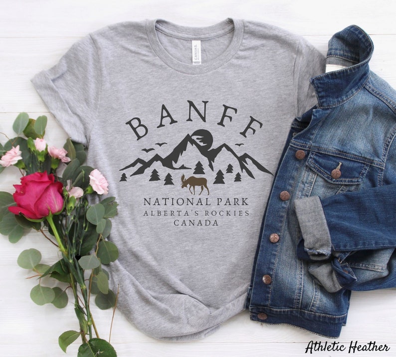 May include: Gray t-shirt with a black graphic design of a mountain range, a moose, and the text "Banff National Park, Alberta's Rockies, Canada".