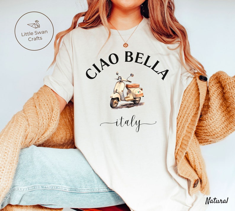 Pu&ograve; includere: Maglietta bianca con una grafica nera di uno scooter vintage e il testo "Ciao Bella - italy".