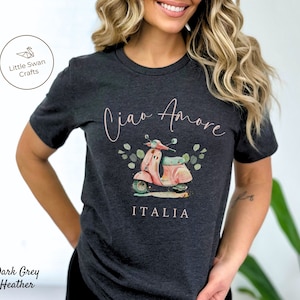 May include: Dark grey heather t-shirt with a pink and white scooter illustration, green leaves, and the text "Ciao Amore" and "ITALIA".