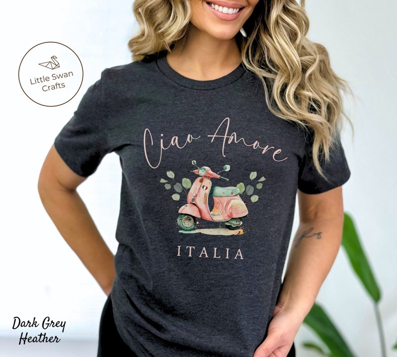 May include: Dark grey heather t-shirt with a pink and white scooter illustration, green leaves, and the text "Ciao Amore" and "ITALIA".