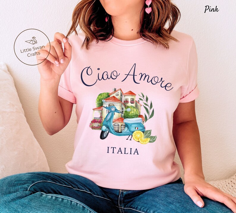 May include: Pink t-shirt with a blue scooter, Italian houses, lemons, and the text "Ciao Amore ITALIA".