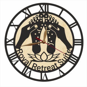 May include: Black and white clock with a wooden background. The clock face features a lotus flower and the text "Royal Retreat Suite".