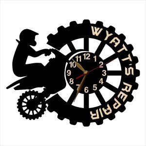 May include: Black and white silhouette of a dirt bike with a clock face in the center. The clock face has black numbers and hands. The words "Wyatt's Repair" are written around the outside of the clock face.