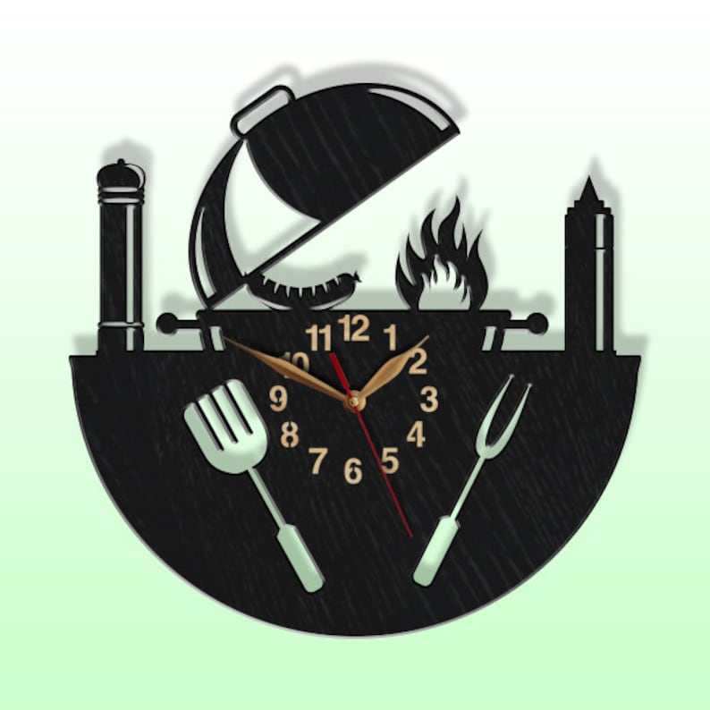 May include: Black and white wood wall clock with a grill, spatula, and fork design. The clock face has Roman numerals and a grill design.