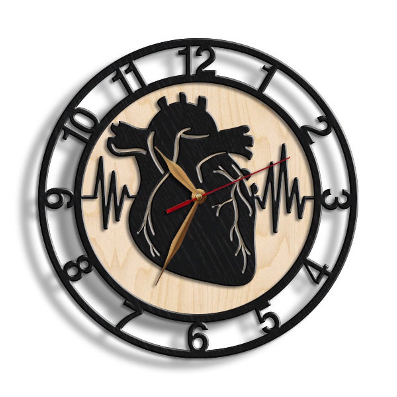 Pode incluir: Rel&oacute;gio de cora&ccedil;&atilde;o anat&ocirc;mico preto e branco com ponteiro dos segundos vermelho e ponteiro das horas dourado. O mostrador do rel&oacute;gio &eacute; rodeado por uma moldura de metal preto com n&uacute;meros brancos.