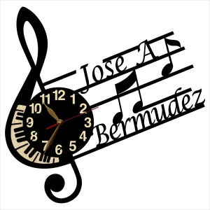 Puede incluir: Reloj blanco y negro con un dise&ntilde;o de clave de sol. La esfera del reloj tiene un fondo negro con n&uacute;meros blancos y manecillas doradas. El reloj est&aacute; rodeado de un pentagrama con los nombres "Jose A. Bermudez" escritos en &eacute;l.