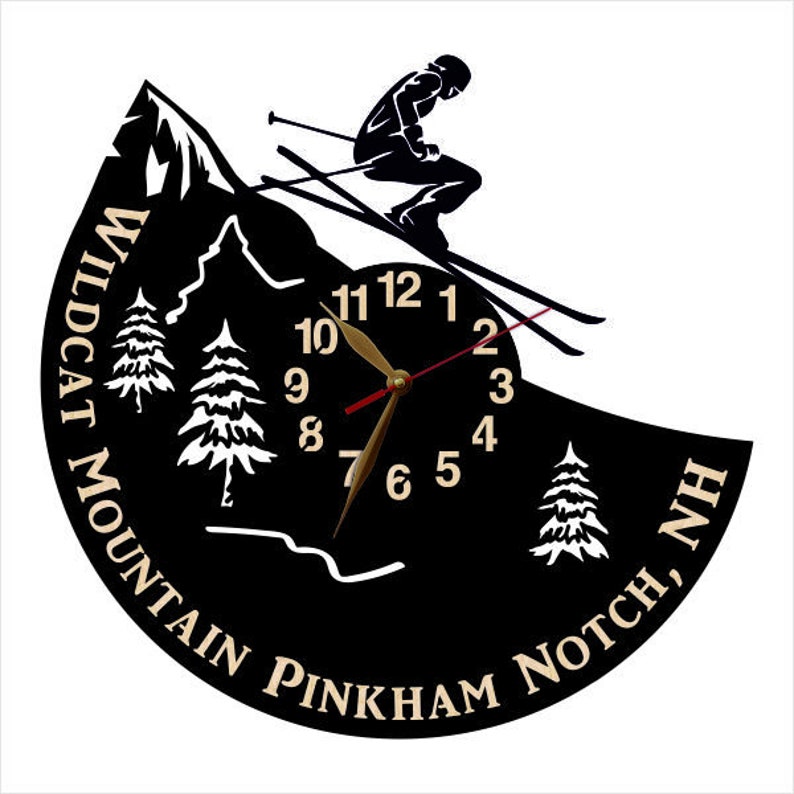 Puede incluir: Reloj de vinilo negro con una silueta de esquiador y una escena de monta&ntilde;a. La esfera del reloj dice "WILDCAT MOUNTAIN PINKHAM NOTCH, NH".