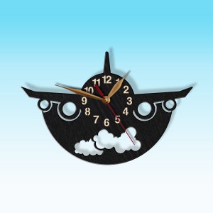 May include: Black wooden aeroplane wall clock with gold hands and white clouds. The clock face has numbers 1-12.