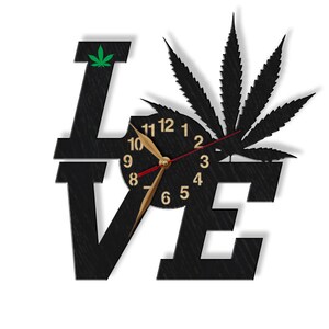 Pu&ograve; includere: Orologio da parete in legno nero a forma della parola "LOVE" con un design a foglia di marijuana e un quadrante dell'orologio al centro.