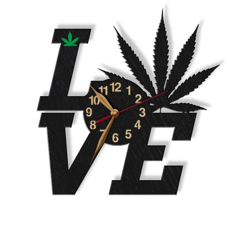 Pu&ograve; includere: Orologio da parete in legno nero a forma della parola "LOVE" con un design a foglia di marijuana e un quadrante dell'orologio al centro.
