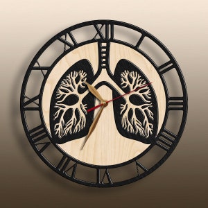 May include: A circular wall clock featuring a light wood center with a black anatomical lung illustration. The clock has a black outer frame with Roman numerals, gold-toned hour and minute hands, and a thin red second hand centered on the lungs.