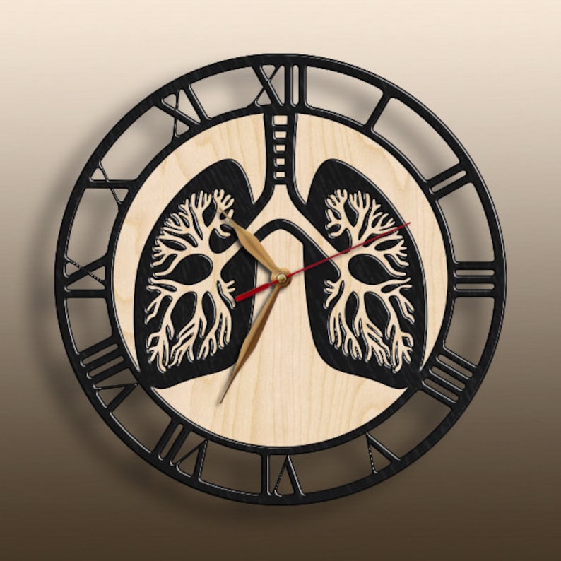 May include: A circular wall clock featuring a light wood center with a black anatomical lung illustration. The clock has a black outer frame with Roman numerals, gold-toned hour and minute hands, and a thin red second hand centered on the lungs.