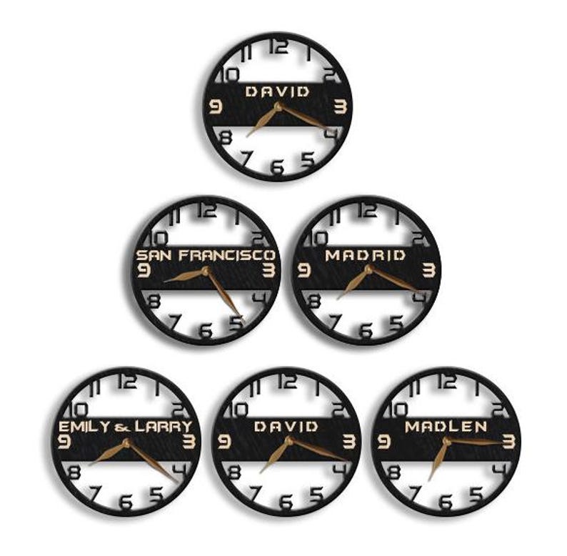 Pu&ograve; includere: Una collezione di orologi da parete circolari neri con lancette color oro. Ogni orologio presenta un nome o una localit&agrave; diversa: "DAVID", "SAN FRANCISCO", "MADRID", "EMILY & LARRY" e "MADLEN". Gli orologi hanno un design minimalista.