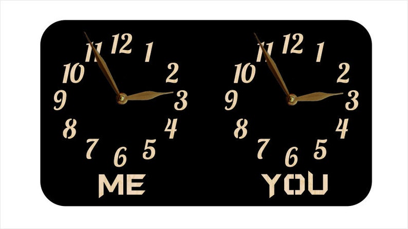 May include: Two black clocks with white numbers and gold hands. The clocks are side by side and the words "ME" and "YOU" are written below them.