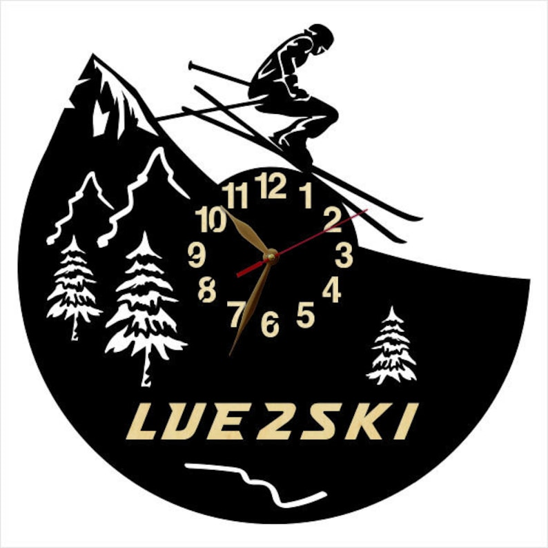 Puede incluir: Reloj de pared negro y blanco con una silueta de esquiador y una escena de monta&ntilde;a. La esfera del reloj tiene n&uacute;meros romanos y una aguja de hora y minutos de color dorado. La esfera del reloj tambi&eacute;n tiene la palabra "LUEZSKI" impresa en dorado.