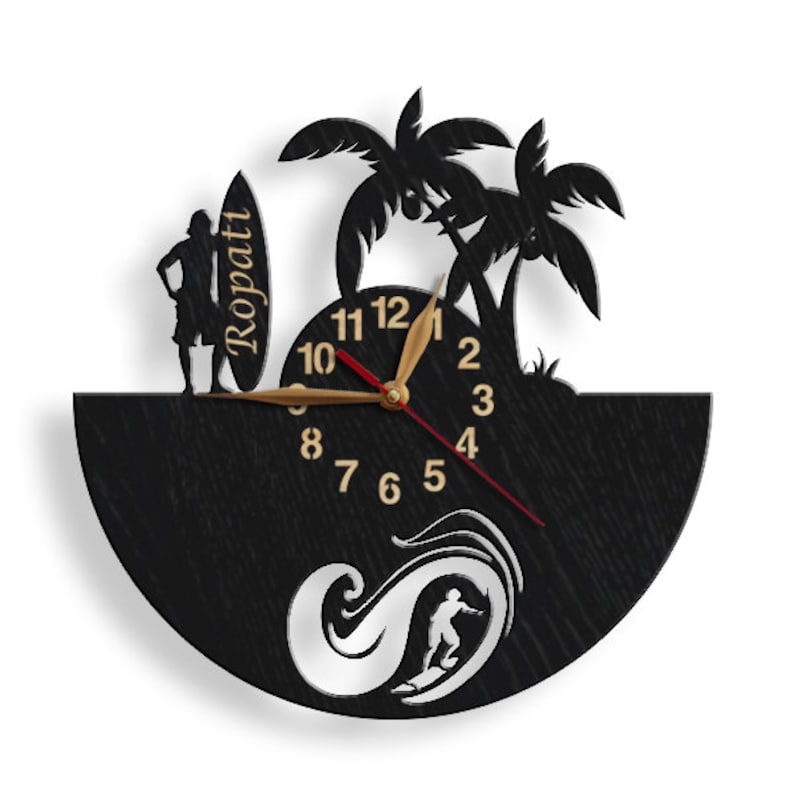 Pu&ograve; includere: Orologio da parete in legno nero a tema surf. L'orologio presenta una silhouette di un surfista, palme e una tavola da surf con la scritta "Ropati". Le lancette dell'orologio sono dorate e rosse.