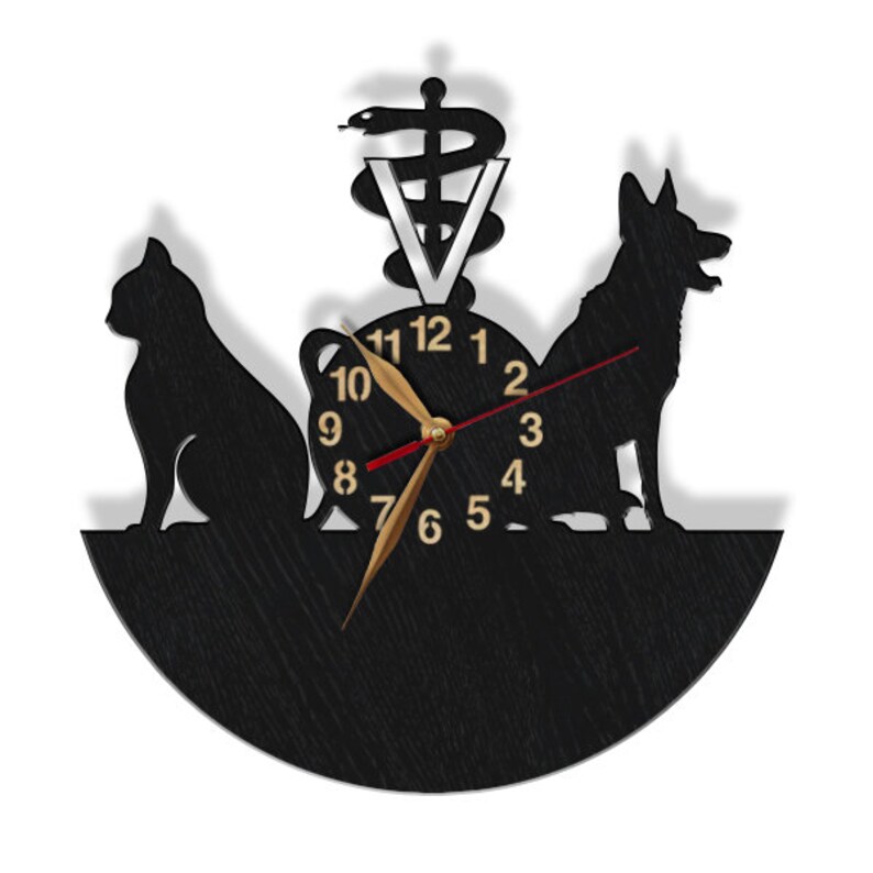 May include: Black wooden clock with a silhouette of a cat and dog, a veterinary symbol, and the numbers 1-12. The clock hands are gold and red.
