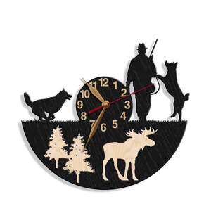 May include: Black silhouette wall clock with a hunter, two dogs, a moose, and trees. The clock face has Roman numerals and gold hands.