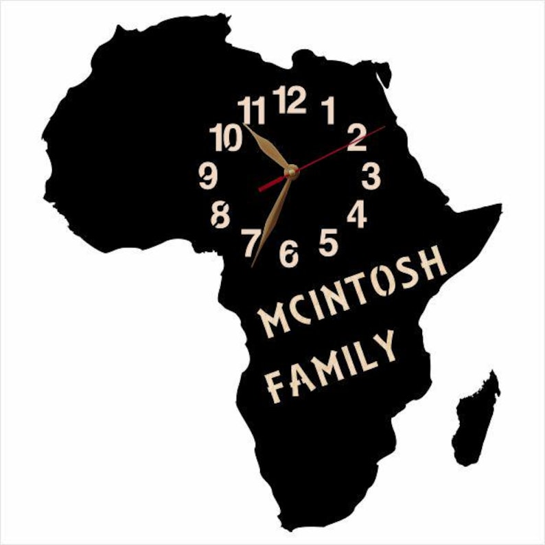 May include: A black wall clock shaped like the African continent. The clock face features white numerals and gold-colored hands. The words "MCINTOSH FAMILY" are displayed in a stylized font.