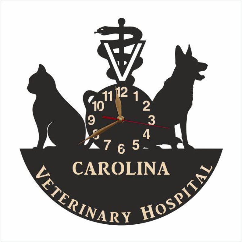 May include: Black and white clock with a cat, dog, and the caduceus symbol. The clock face reads "CAROLINA VETERINARY HOSPITAL".