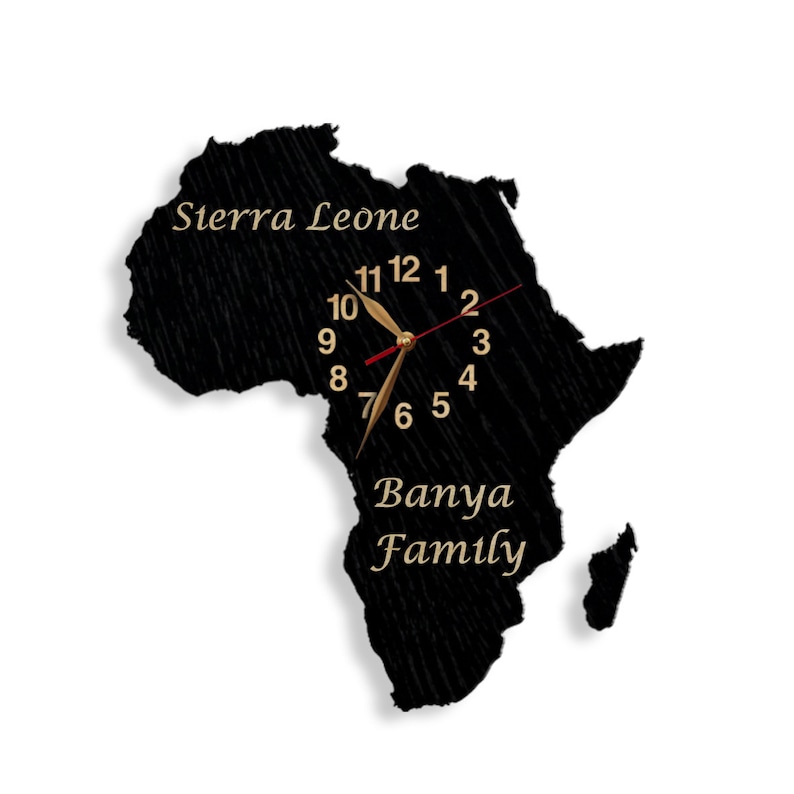 May include: A black wall clock shaped like the African continent. The clock face features gold-colored numerals and hands, with the words "Sierra Leone" and "Banya Family" in gold script.