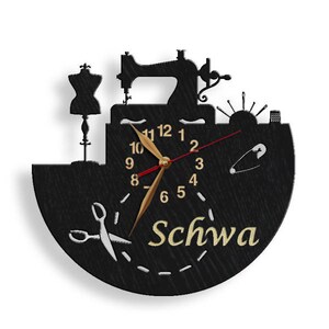 May include: Black wooden clock with a sewing machine, a dress form, and a pair of scissors. The clock face has gold numbers and hands, and the word "Schwa" is written in gold lettering below the clock face.