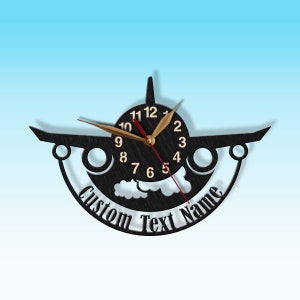 May include: Black wooden aeroplane clock with gold clock hands and a white cloud design. The clock face has black numbers and a red second hand. The clock has a custom text name area that says "Custom Text Name".