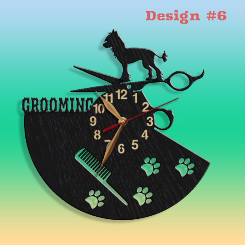 May include: Black wooden clock with a grooming theme. The clock face features a pair of scissors, a comb, and paw prints. The words "Grooming" are displayed at the top of the clock face. The clock hands are gold and red.