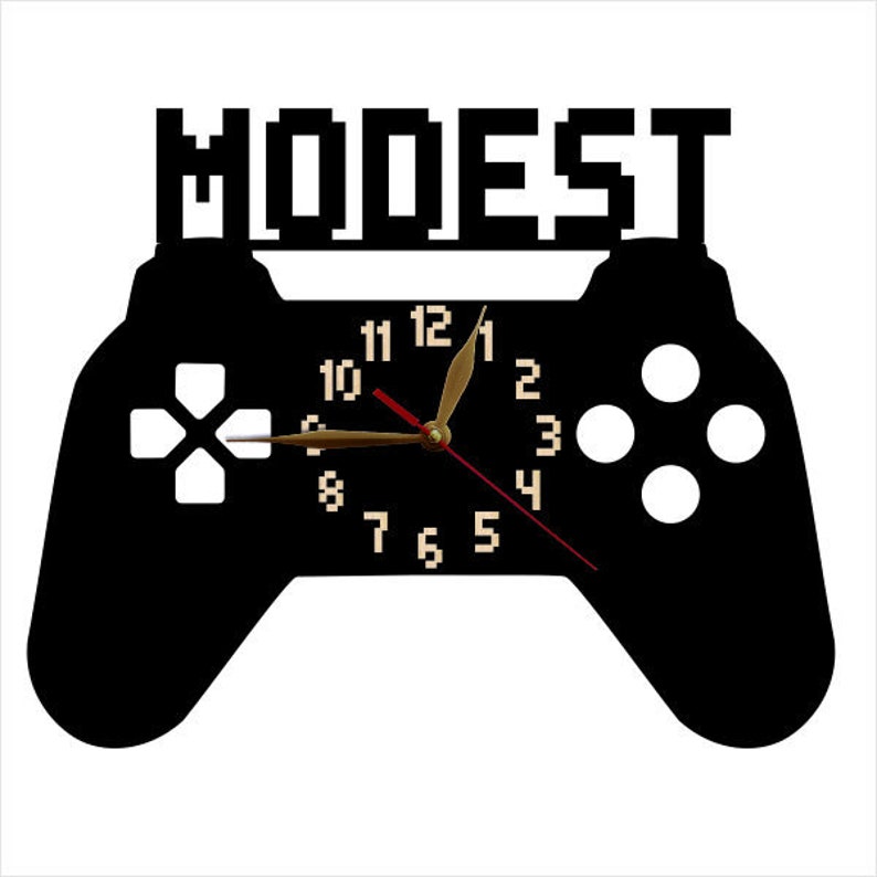 May include: Black and white gamer controller clock with the word "MODEST" above the clock face. The clock face has black numbers and gold hands.