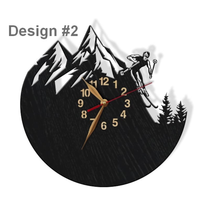 Puede incluir: Reloj negro con una escena de monta&ntilde;a blanca y un esquiador en silueta. La esfera del reloj tiene n&uacute;meros y manecillas dorados. El reloj tiene un di&aacute;metro de 30 cm.