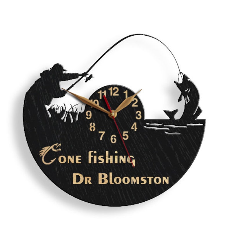 May include: Black wooden clock with a silhouette of a person fishing. The clock face has gold numbers and hands. The text "Gone fishing Dr Bloomston" is written below the clock face.