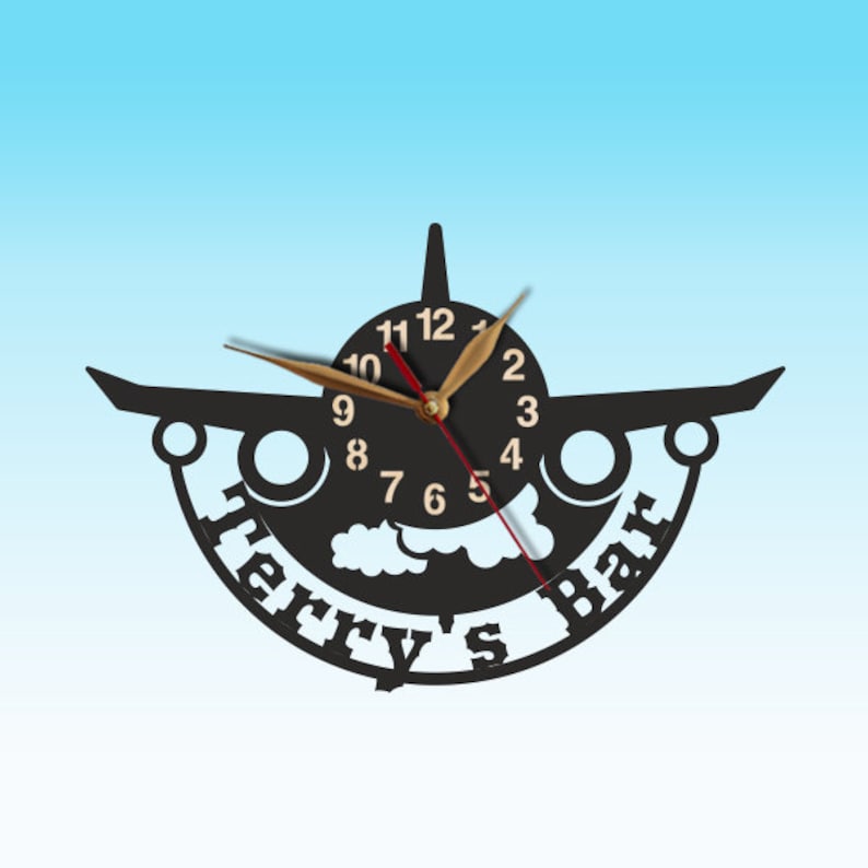 May include: Black airplane-shaped wall clock with gold hands and a white cloud design. The clock face has the text "Terry's Bar" around the edge.