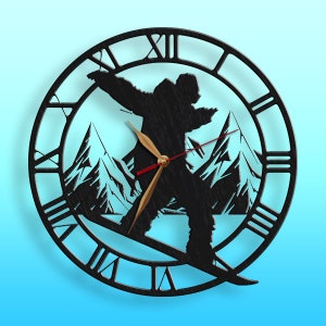 May include: Black wooden wall clock with a silhouette of a person snowboarding down a mountain. The clock face has Roman numerals and a gold-colored hour hand and red minute hand.