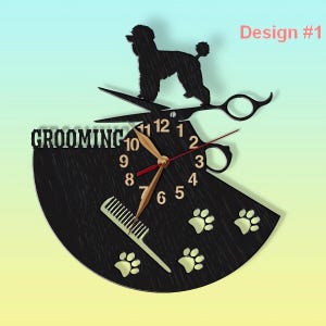May include: Black and gold clock with a grooming theme. The clock features a silhouette of a poodle, scissors, a comb, and paw prints. The clock face says "Grooming" and has the numbers 1 through 12.