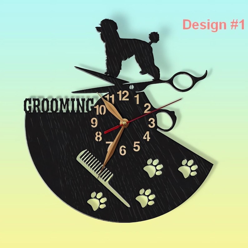 May include: Black and gold clock with a grooming theme. The clock features a silhouette of a poodle, scissors, a comb, and paw prints. The clock face says "Grooming" and has the numbers 1 through 12.