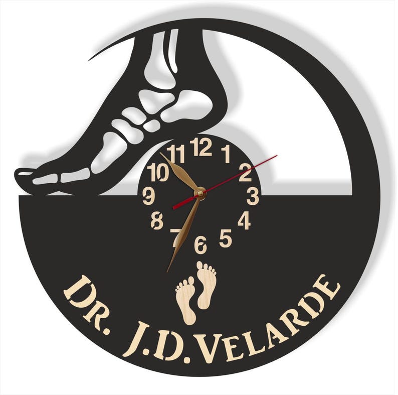 May include: A black and tan wall clock featuring a foot skeleton silhouette above a clock face. The clock hands are gold, and the second hand is red. The clock also includes the text "DR. J.D. VELARDE" and two foot prints.