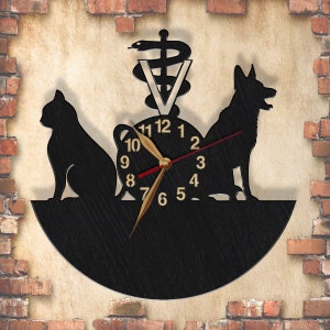 May include: Black and white silhouette clock with a cat, dog, and a veterinary symbol. The clock face has Roman numerals and gold hands.