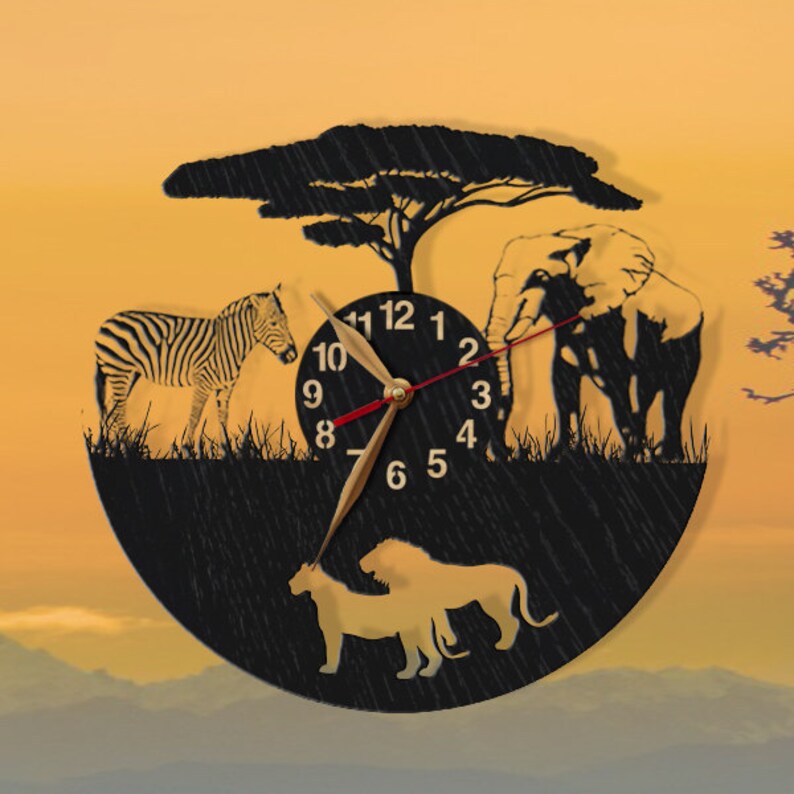 May include: Black and white silhouette clock with a zebra, elephant, and lion on a black background. The clock face has Roman numerals and a gold hand.