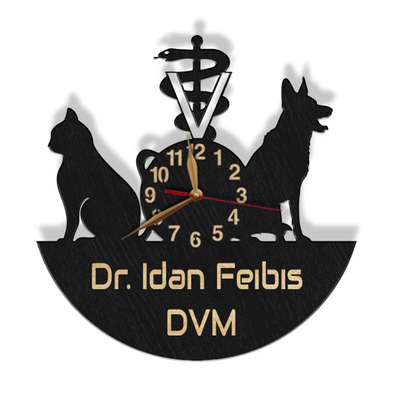 May include: Black wooden clock with a gold clock face and hands. The clock features a silhouette of a cat and a dog, a medical symbol, and the text "Dr. Idan Felbis DVM".