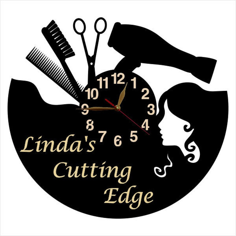 May include: Black and white silhouette wall clock with a hair dryer, scissors, combs, and a woman's face. The clock face has gold numbers and hands. The text "Linda's Cutting Edge" is printed below the clock face.
