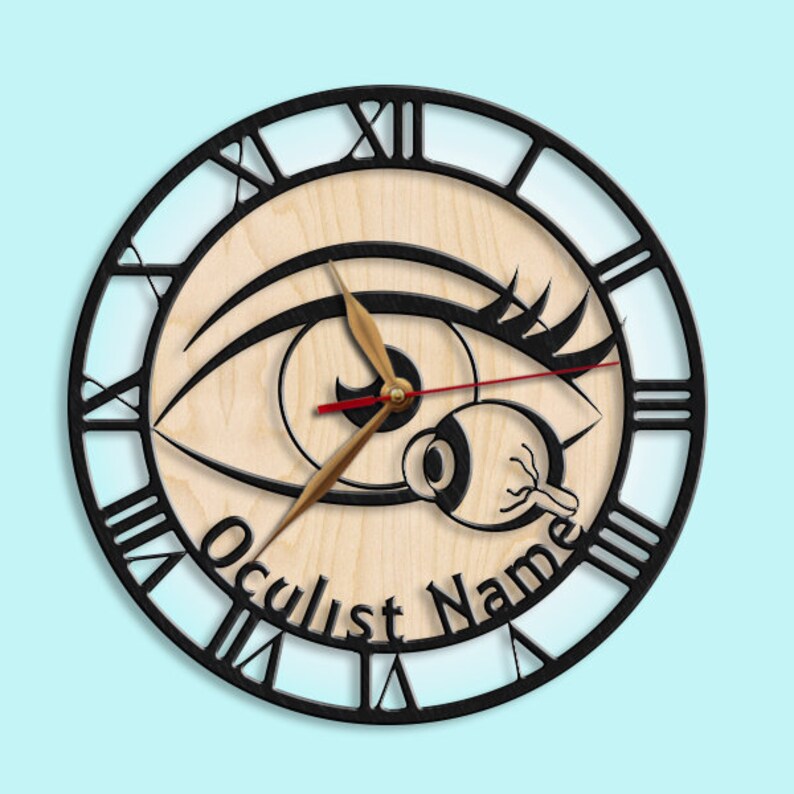 May include: A black and white clock with a large eye design. The clock face is made of wood and has Roman numerals. The clock hands are gold and red. The text "Oculist Name" is printed on the clock face.