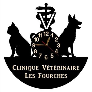May include: Black and white silhouette of a cat, dog, and a snake with a clock face in the center. The clock face has black numbers and gold hands. The text "Clinique V&eacute;t&eacute;rinaire Les Fourches" is written in a black circle below the clock.