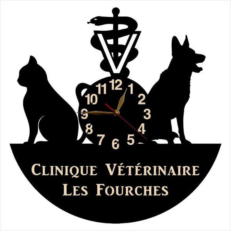 May include: Black and white silhouette of a cat, dog, and a snake with a clock face in the center. The clock face has black numbers and gold hands. The text "Clinique V&eacute;t&eacute;rinaire Les Fourches" is written in a black circle below the clock.