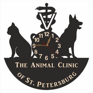 May include: Black and white clock with a cat and dog silhouette, a caduceus symbol, and the text "The Animal Clinic of St. Petersburg".