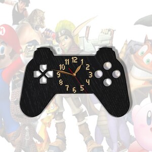 May include: Black wooden wall clock shaped like a video game controller with gold-colored hands and numbers. The clock face has a wood grain texture.