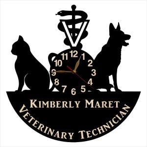 May include: Black and white silhouette of a cat, dog, and the caduceus symbol with a clock face in the center. The clock face has black Roman numerals and gold hands. The text "KIMBERLY MARET VETERINARY TECHNICIAN" is written in a gold font around the clock face.