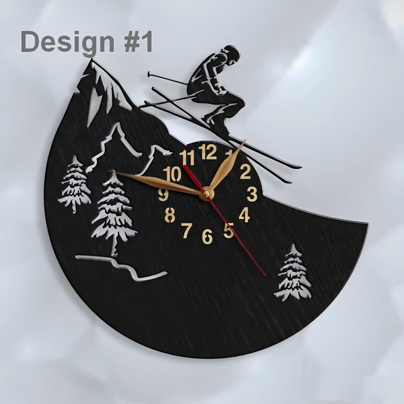 Puede incluir: Reloj de madera negro con una silueta de esquiador sobre un dise&ntilde;o de monta&ntilde;a. La esfera del reloj tiene n&uacute;meros y manecillas dorados, y una manecilla de segundos roja.