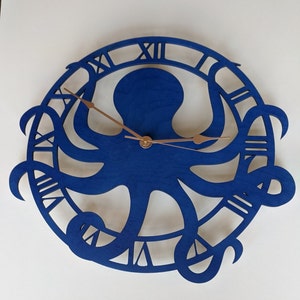May include: A blue wooden wall clock with an octopus design. The clock face has Roman numerals and copper-coloured hands. The octopus is central within a circular frame, creating a nautical theme for home decor.